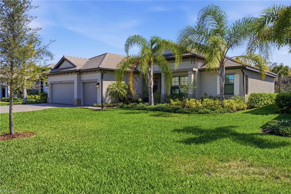 View of front of home featuring an attached garage, a front lawn, concrete driveway, and stucco siding