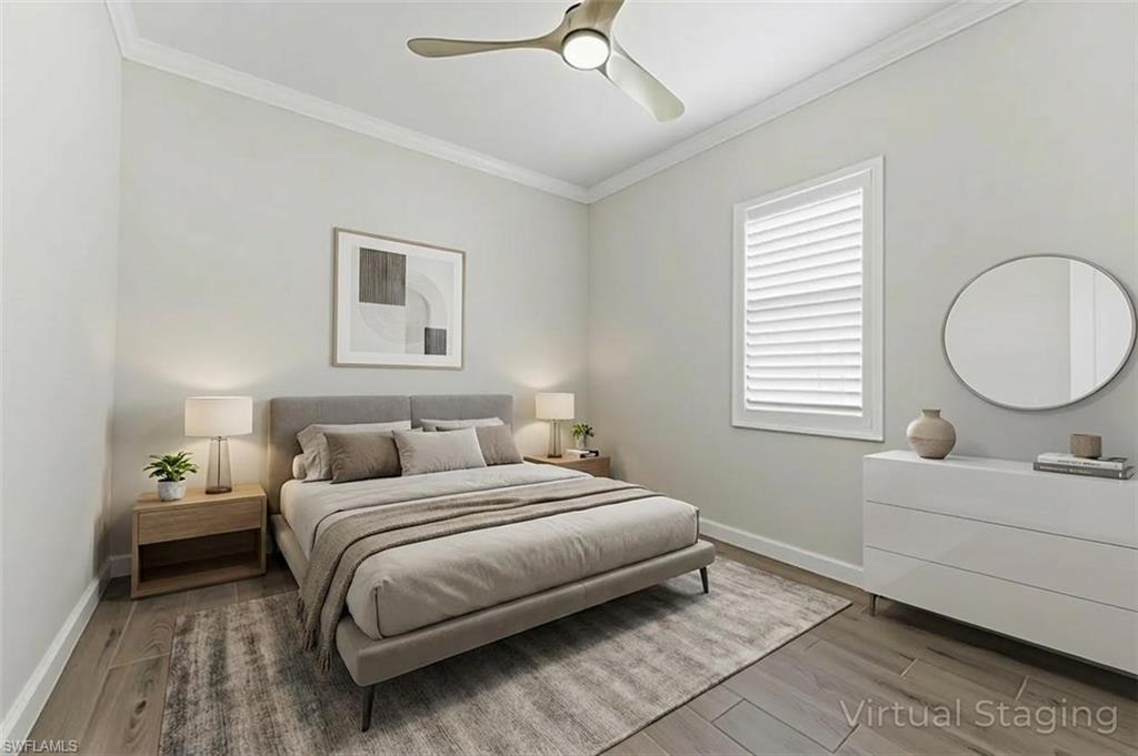 Bedroom featuring light wood finished floors, crown molding, and a ceiling fan - Virtually Staged