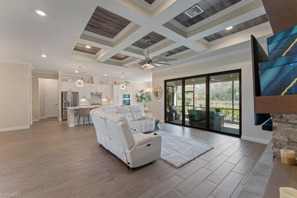 Living area featuring ornamental molding, wood finish floors, coffered ceiling, ceiling fan, and recessed lighting