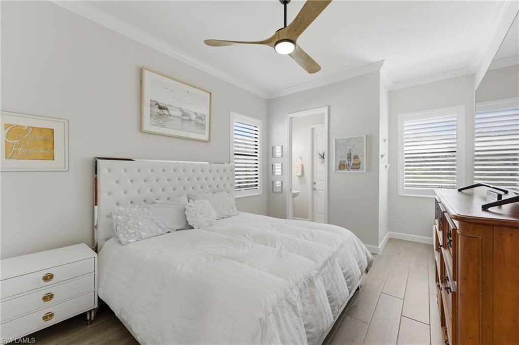 Bedroom featuring ornamental molding, ceiling fan, and light wood-style floors