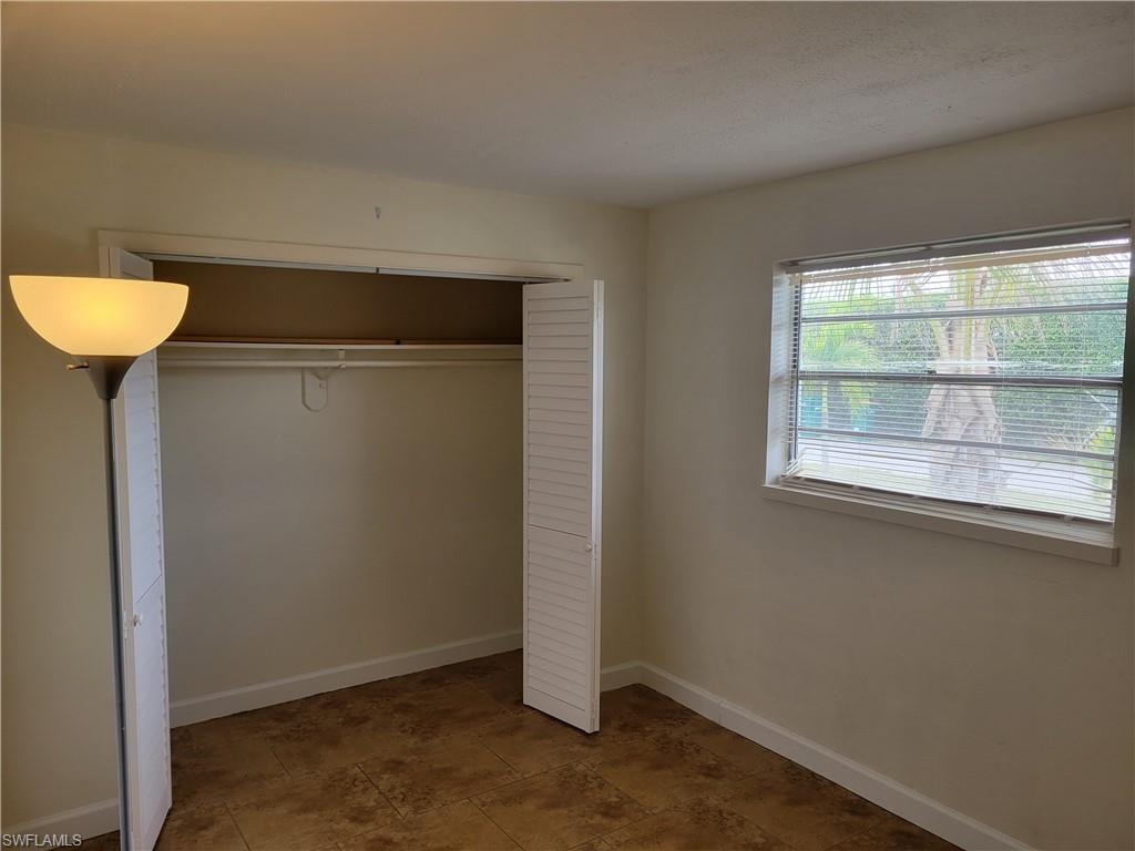 Unfurnished bedroom featuring baseboards and a closet