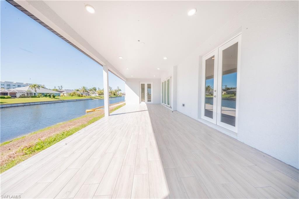Wooden terrace with french doors and a water view