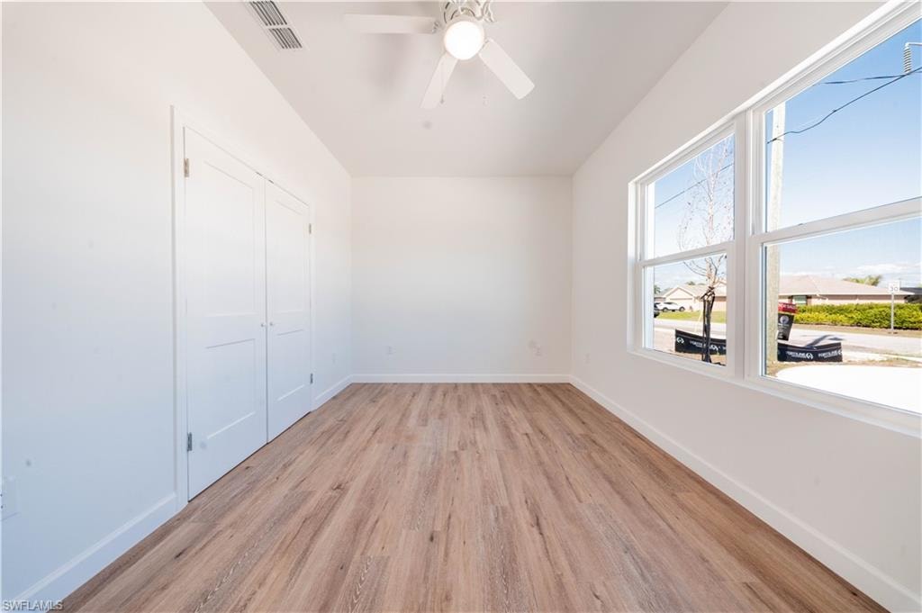 Unfurnished bedroom featuring light wood-style floors, a closet, and ceiling fan