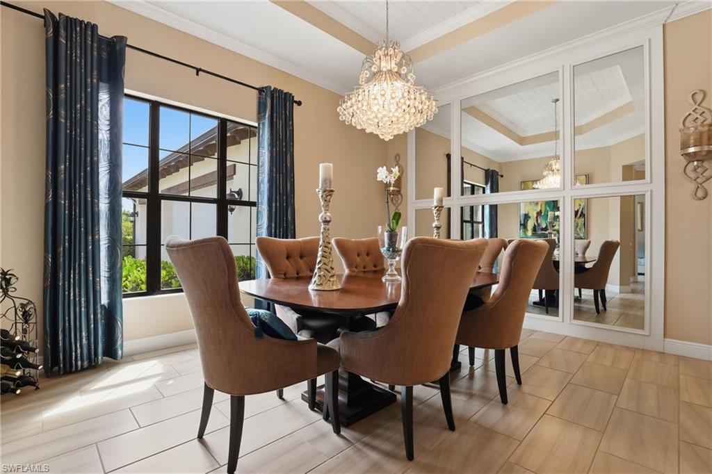 Dining area featuring hanging lights, ornamental molding, and a tray ceiling