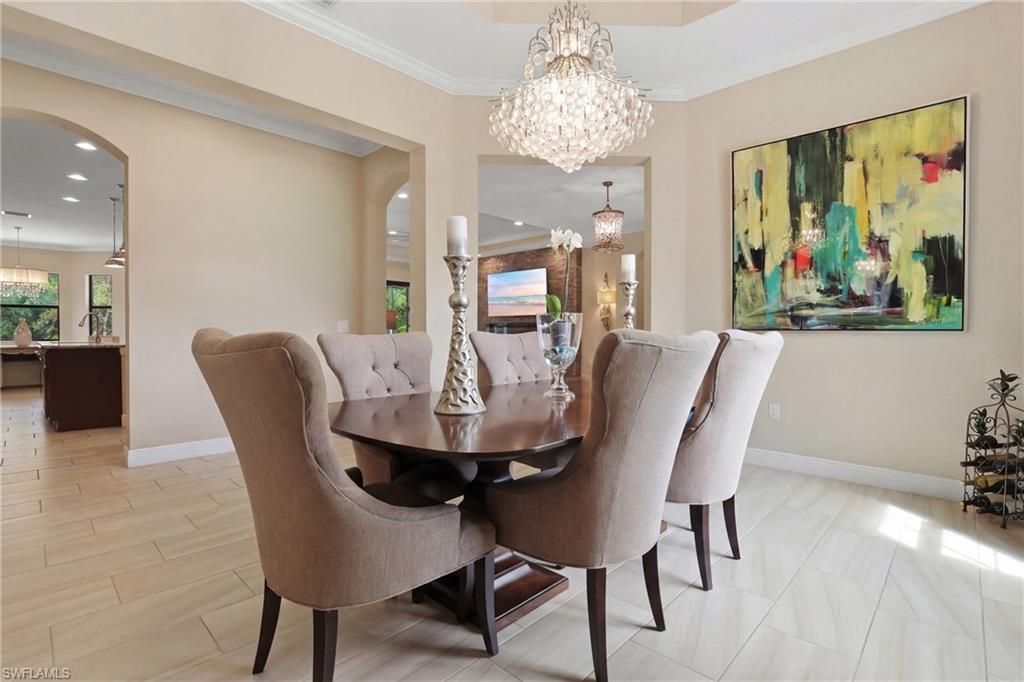 Dining room with a chandelier, ornamental molding, and arched walkways