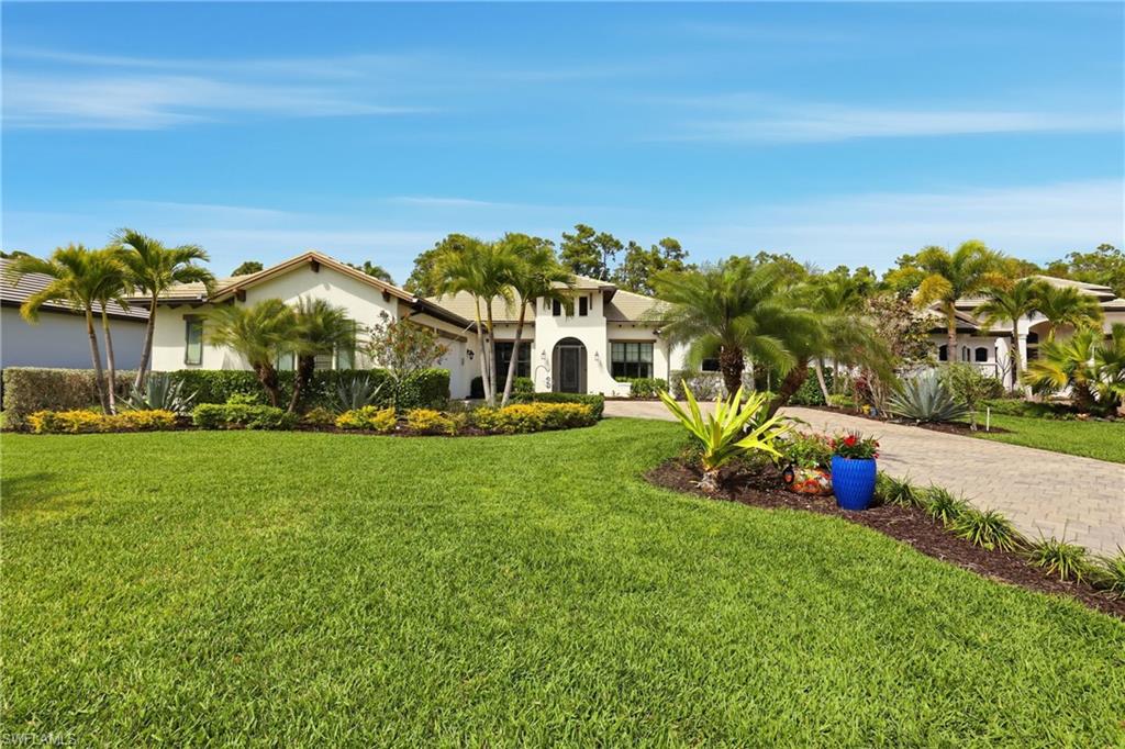 Mediterranean / spanish-style home featuring stucco siding, a front yard, and curved driveway