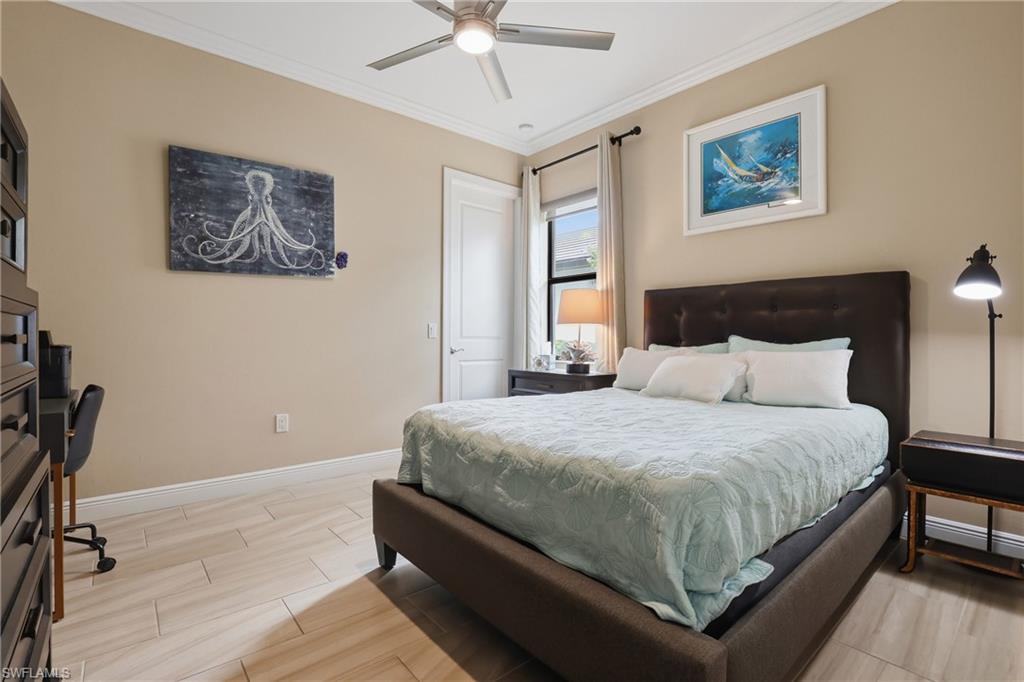 Bedroom with ornamental molding, wood tiled floors, a desk, and ceiling fan