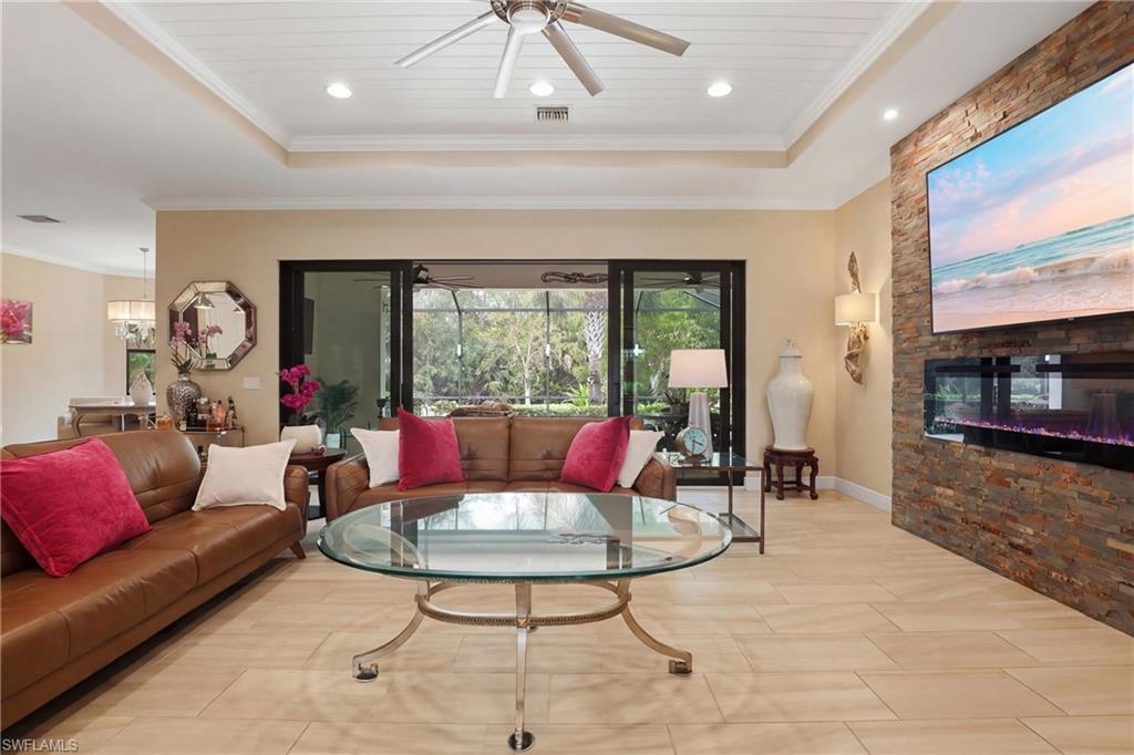 Living room with ceiling fan, ornamental molding, a wooden tray ceiling, and recessed lighting