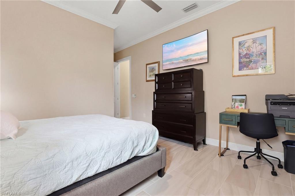 Bedroom with an office area, a ceiling fan, and crown molding