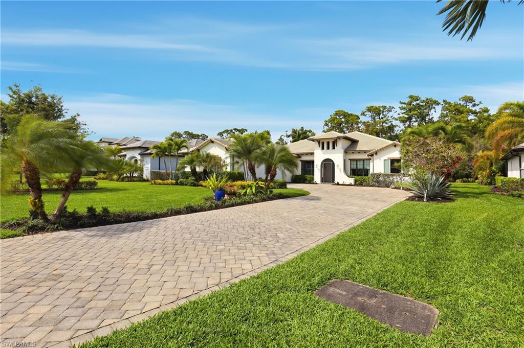 Mediterranean / spanish house featuring a front yard, decorative driveway, and stucco siding
