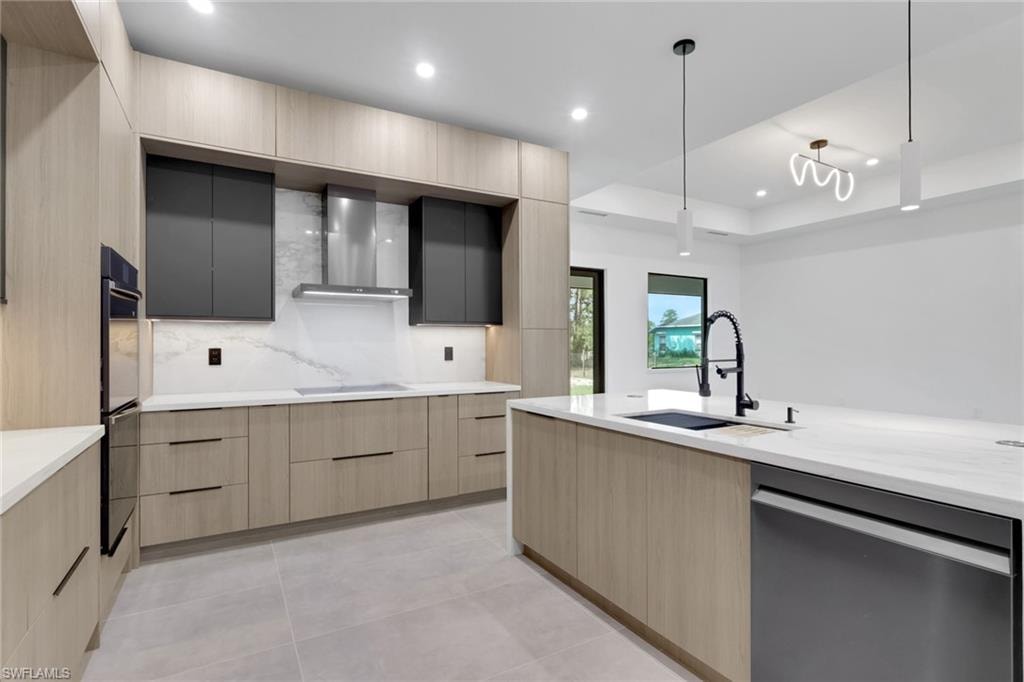 Gourmet kitchen with light wood-finish cabinetry, dark contrasting upper cabinets, and a large central island