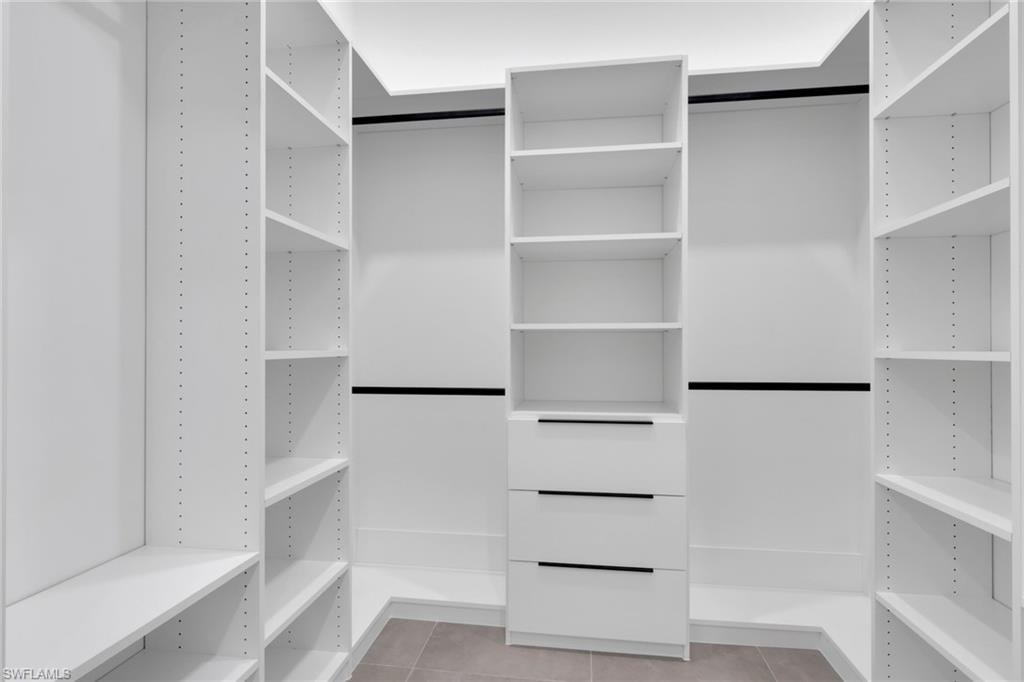 White custom closet system featuring adjustable shelving and hanging rods