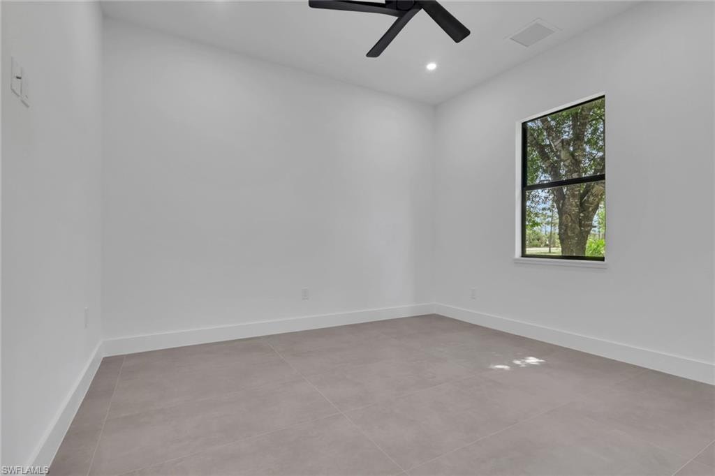 Interior room with clean white walls and light gray tile flooring
