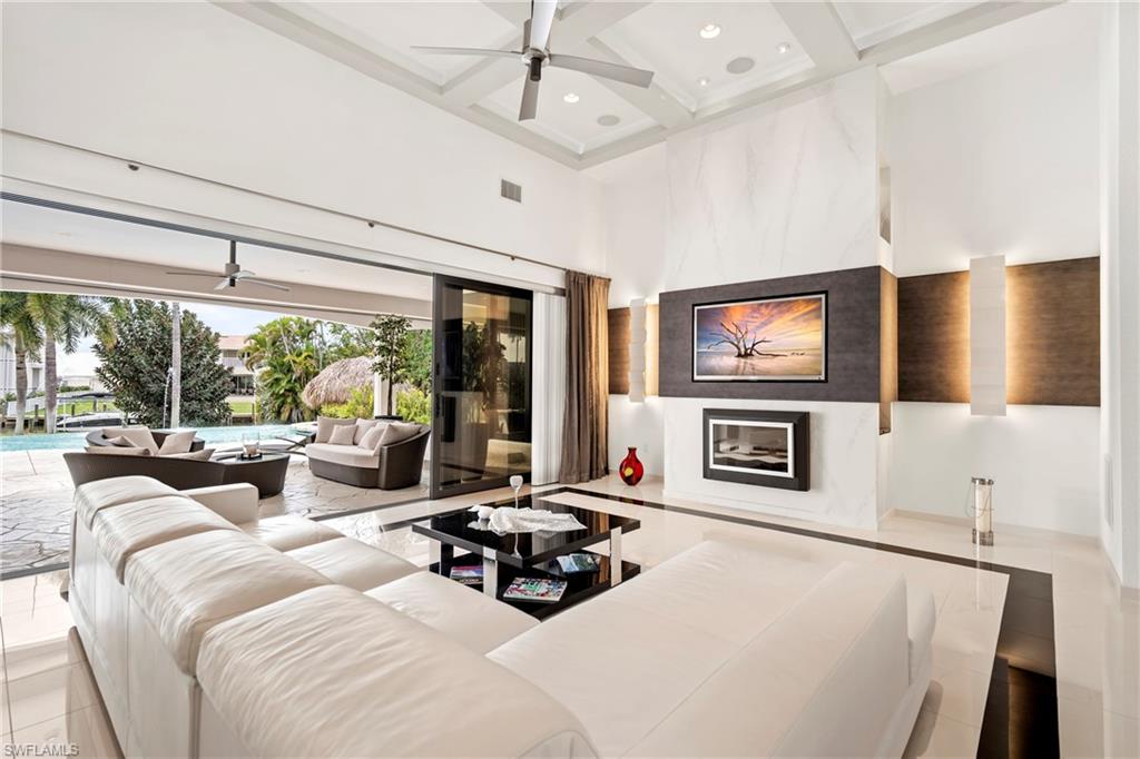 Living room with a ceiling fan, coffered ceiling, and recessed lighting