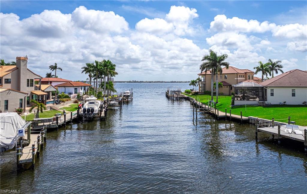 Dock area with a water view, a residential view, a lawn, and boat lift