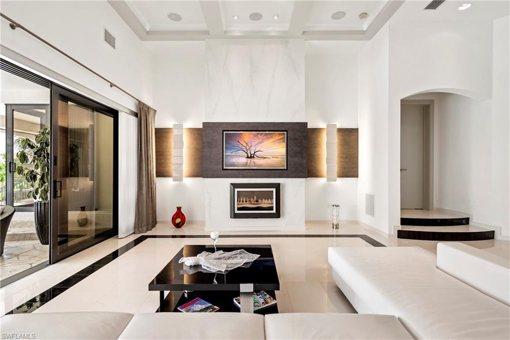 Sunken living room featuring inlaid floor details, a fireplace, recessed lighting, and coffered ceiling