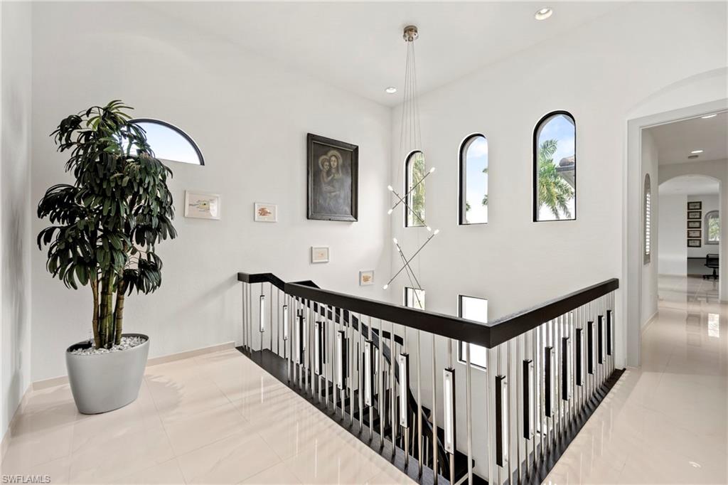 Hall featuring arched walkways and baseboards