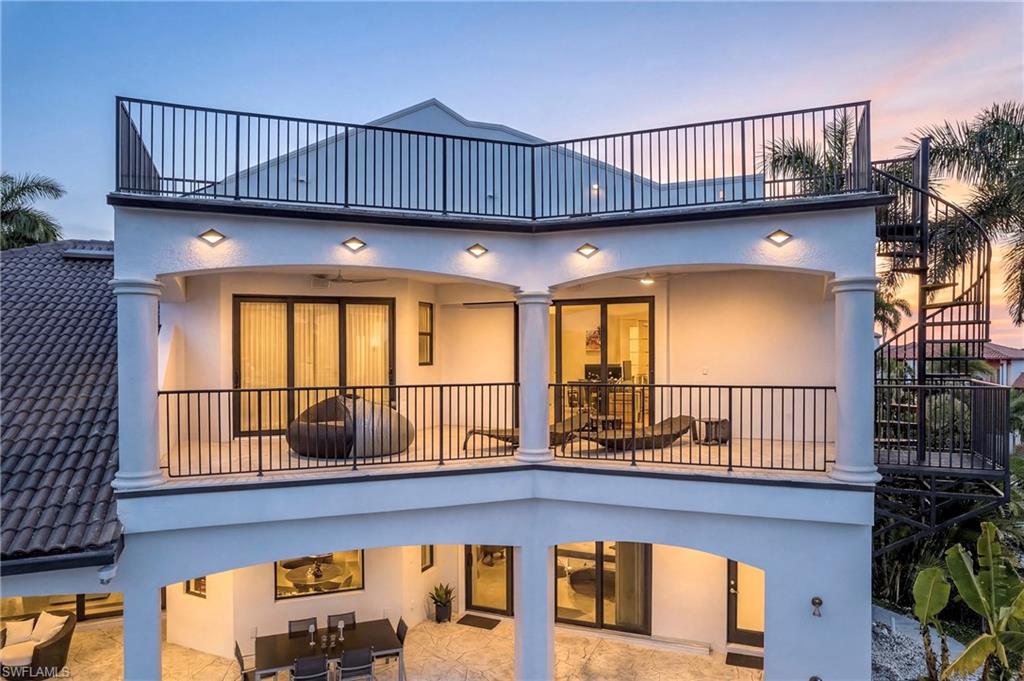 Back of property at dusk with a patio, stucco siding, and outdoor dining area