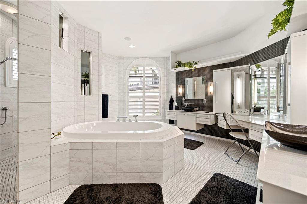 Full bathroom with vanity, a bath, light tile patterned flooring, backsplash, and a stall shower
