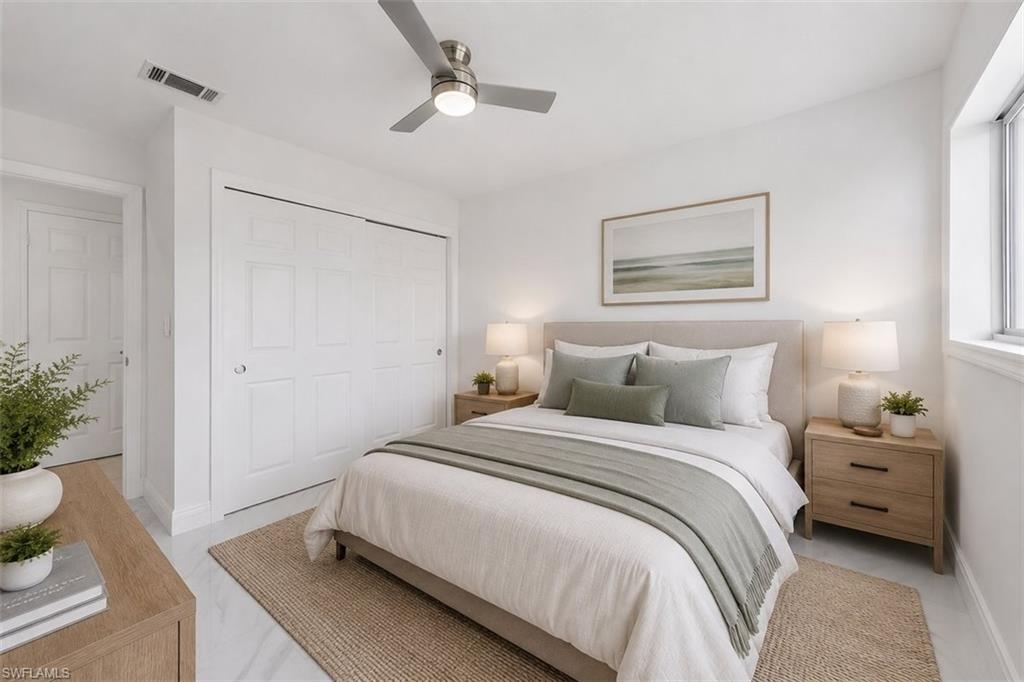 Bedroom featuring a ceiling fan with integrated lighting, a window with white trim, and white bi-fold closet doors