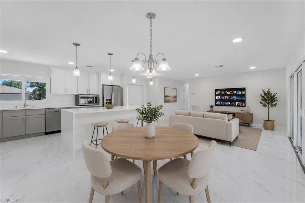 Open-concept living area featuring white tile flooring and recessed lighting