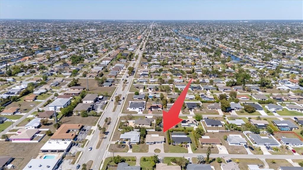Aerial view of property and surrounding area featuring nearby suburban area
