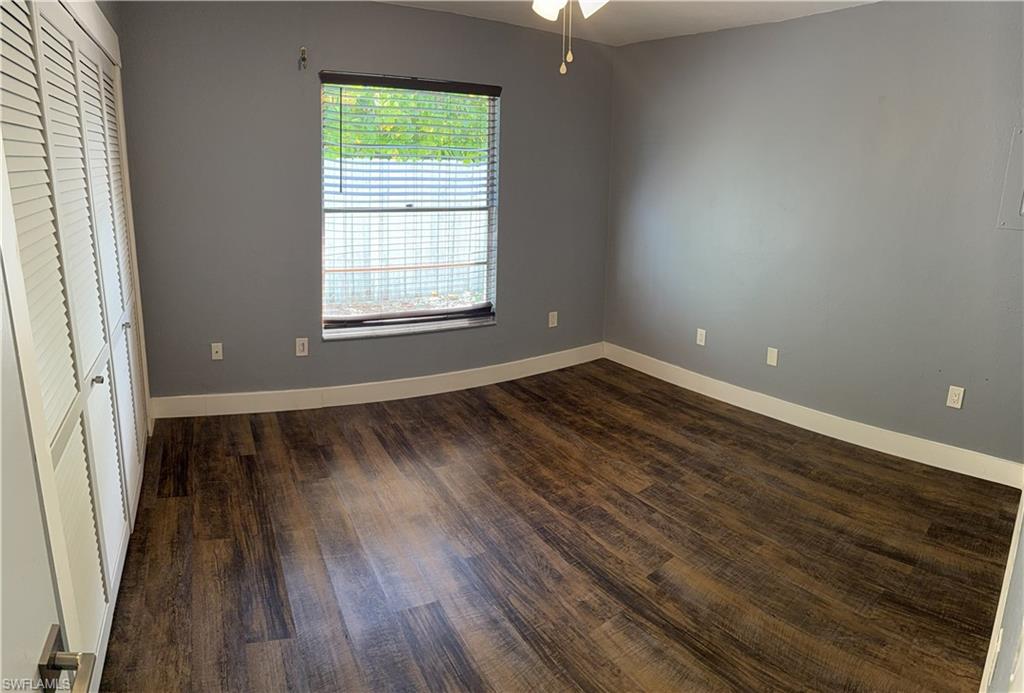 Guest House, Unfurnished bedroom with a closet, dark wood-style flooring, and a ceiling fan