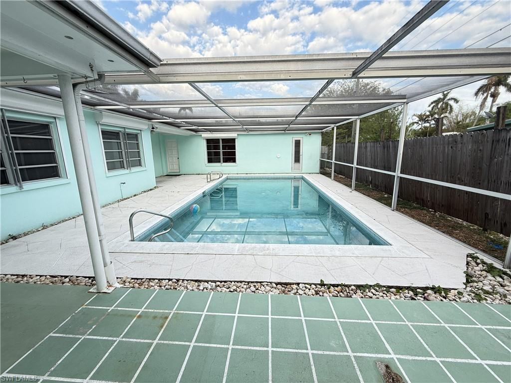 View of pool with a sunroom, patio surround, and a lanai