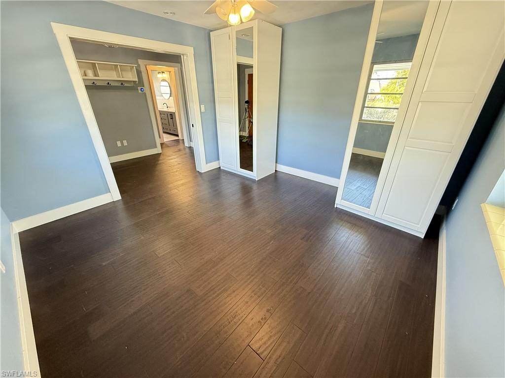Unfurnished bedroom featuring dark wood finished floors and a ceiling fan