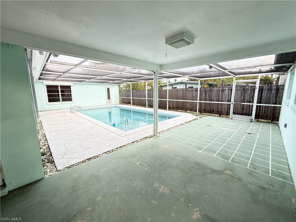 View of pool featuring a lanai, patio surround, and a fenced backyard