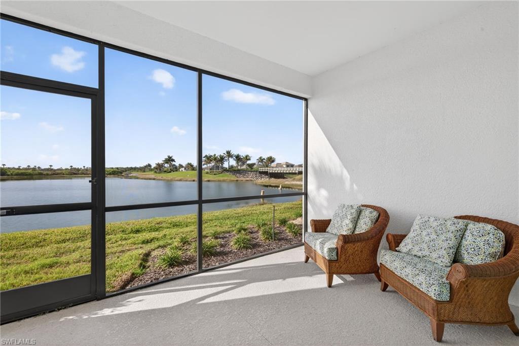 Sunroom / solarium with a water view and a textured wall