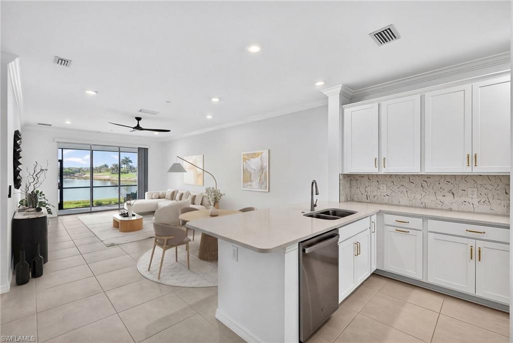 Kitchen with a peninsula, white cabinetry, ceiling fan, stainless steel dishwasher, and recessed lighting