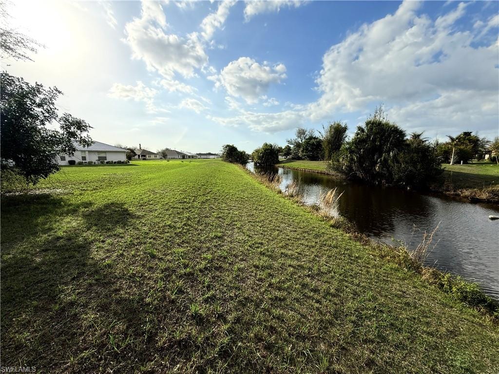 View of green lawn featuring a water view