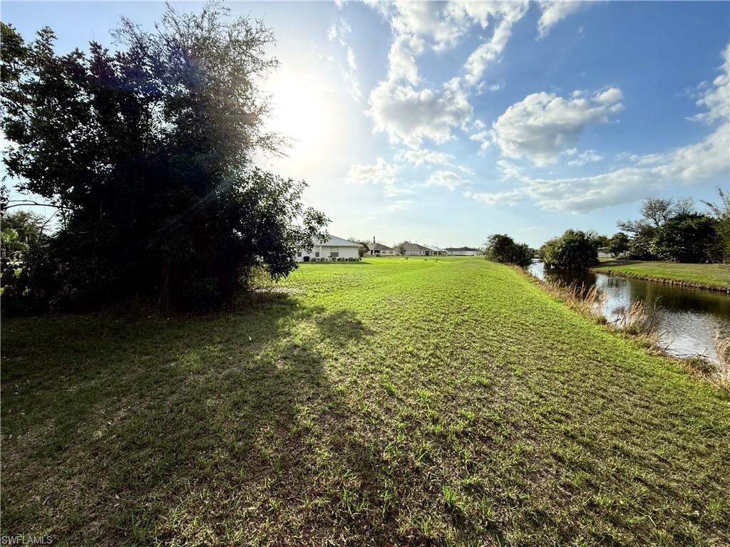 View of grassy yard with a water view