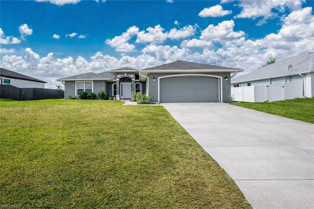 Ranch-style house featuring an attached garage, stucco siding, and driveway