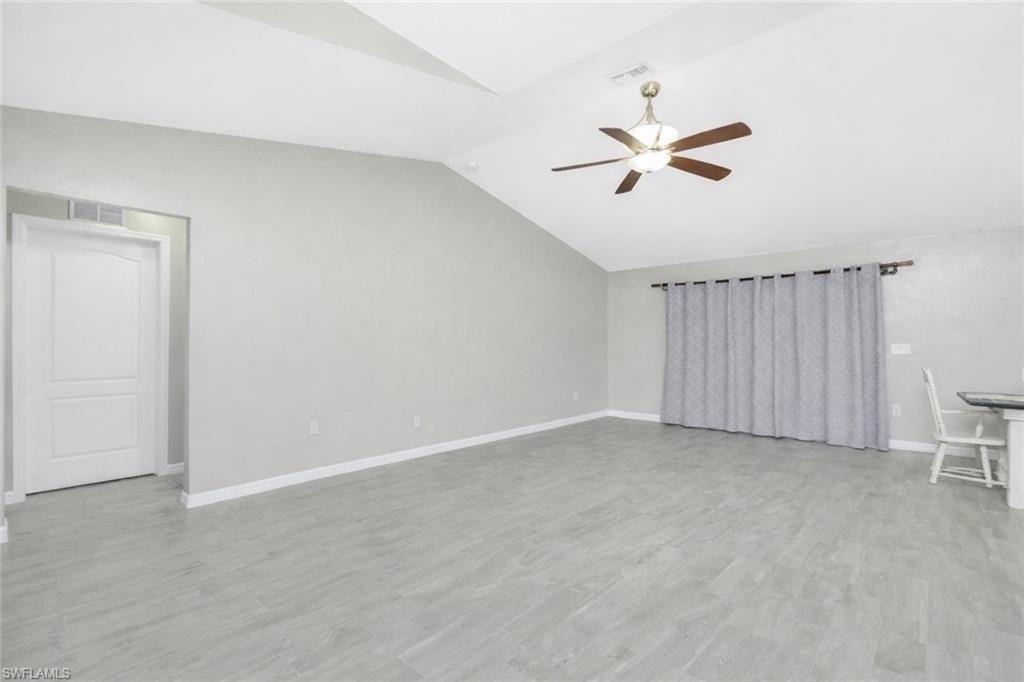 Unfurnished living room featuring lofted ceiling, a ceiling fan, and light wood finished floors
