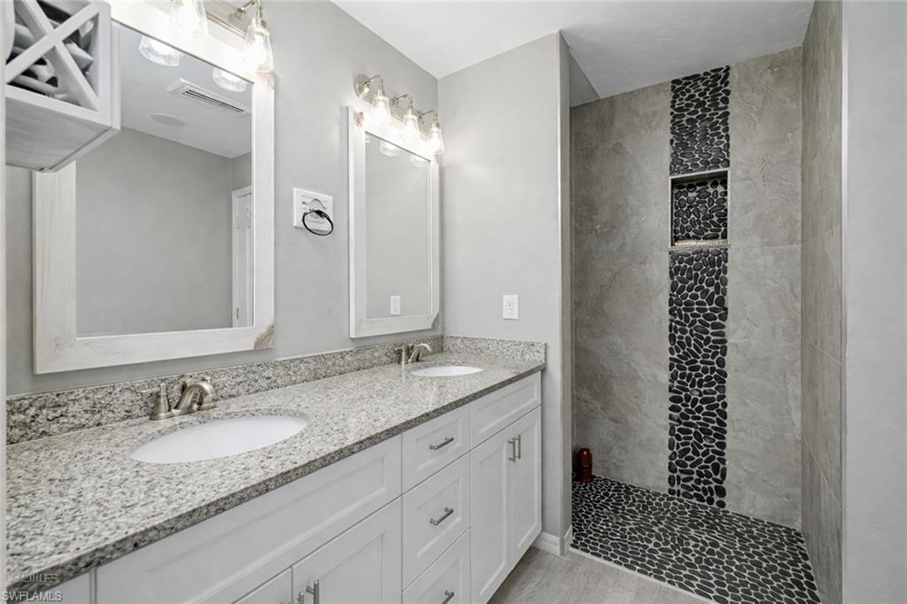 Bathroom featuring a walk in shower and double vanity