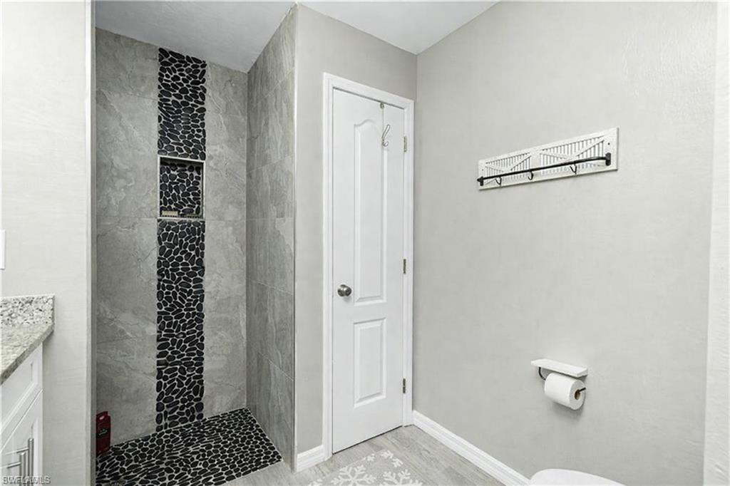 Full bathroom with a stall shower, vanity, and light wood finished floors