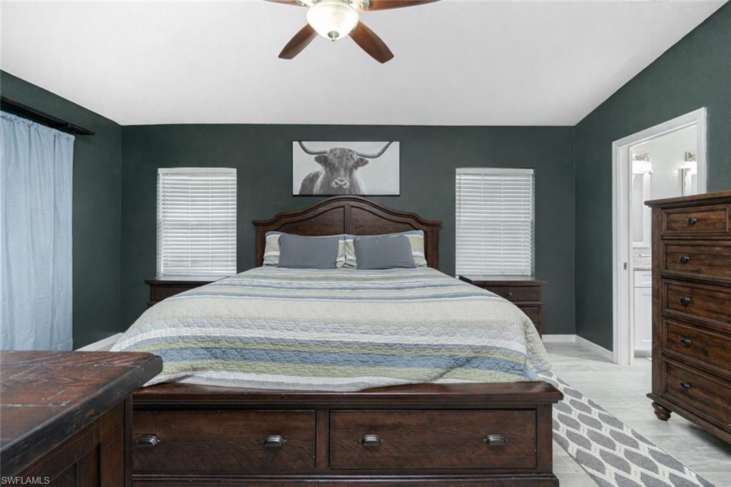 Bedroom with ceiling fan, ensuite bath, and vaulted ceiling