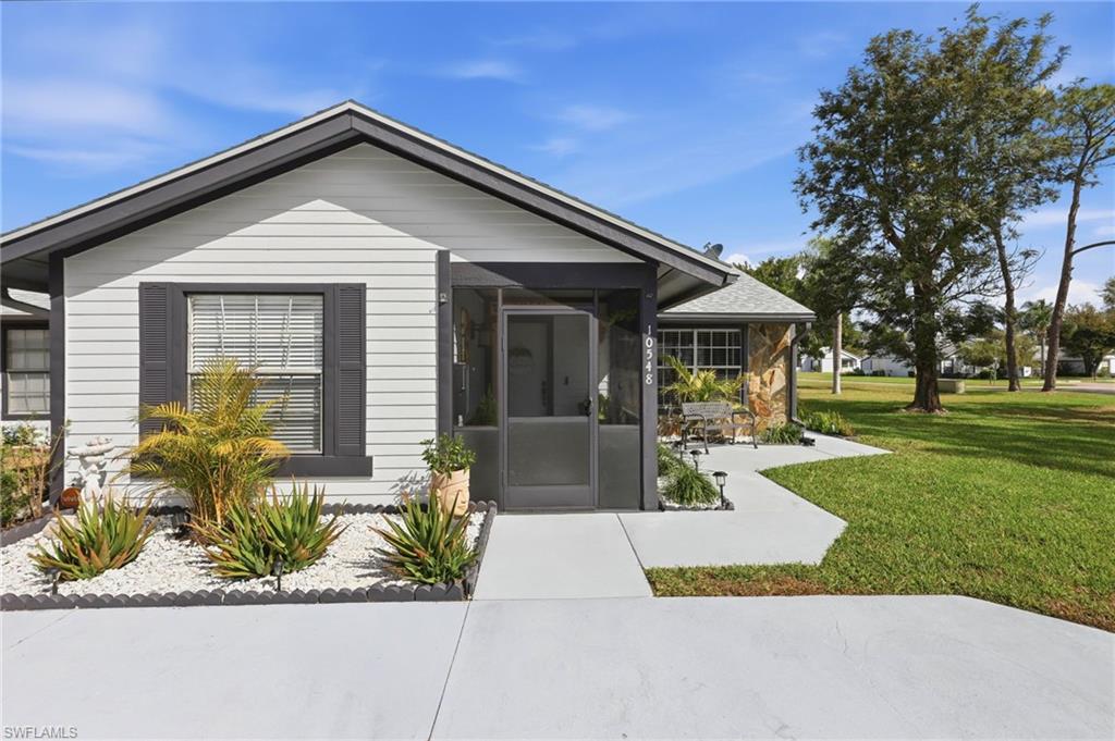 Doorway to property with a lawn and a sunroom