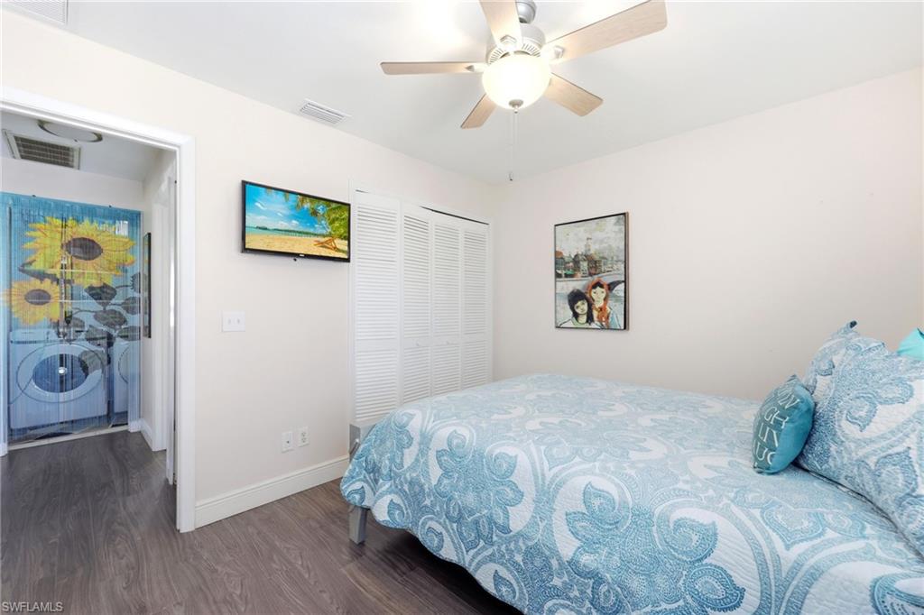 Bedroom with dark wood-style floors, a closet, and a ceiling fan