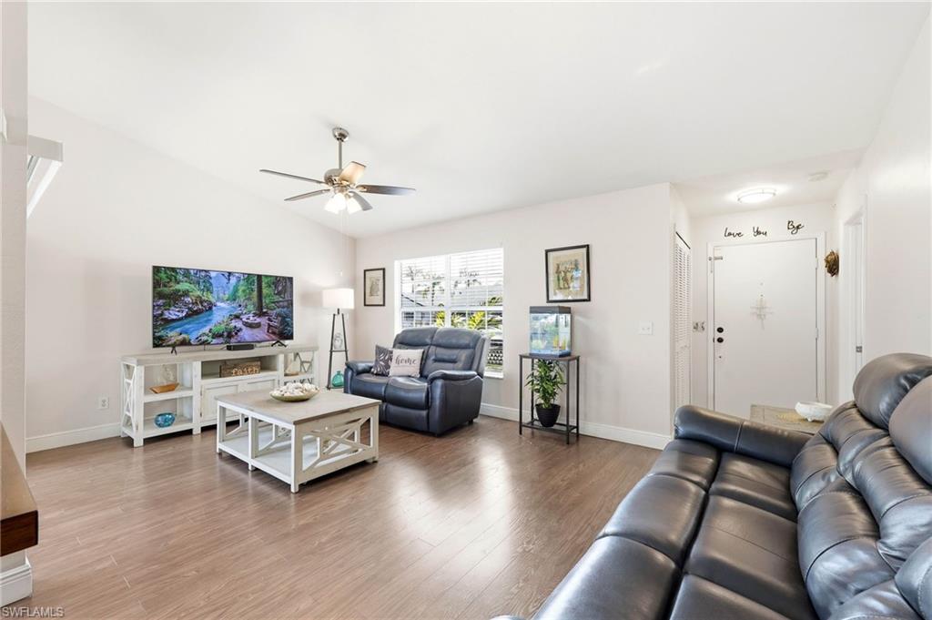 Living room featuring wood finished floors, ceiling fan, and lofted ceiling