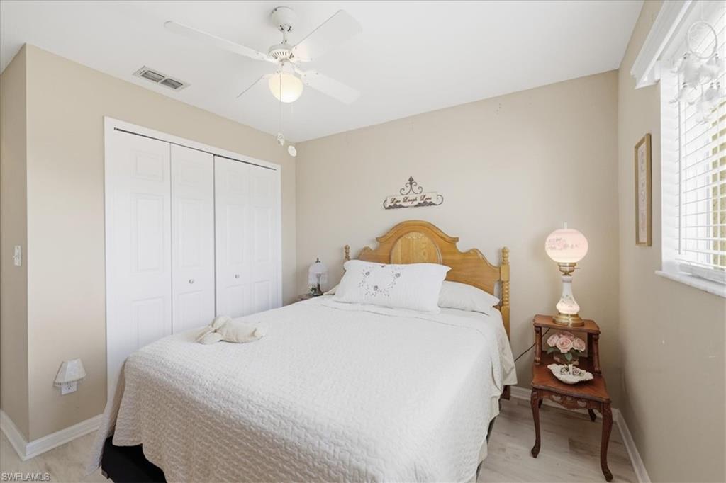 Bedroom with ceiling fan, a closet, and light wood-style floors