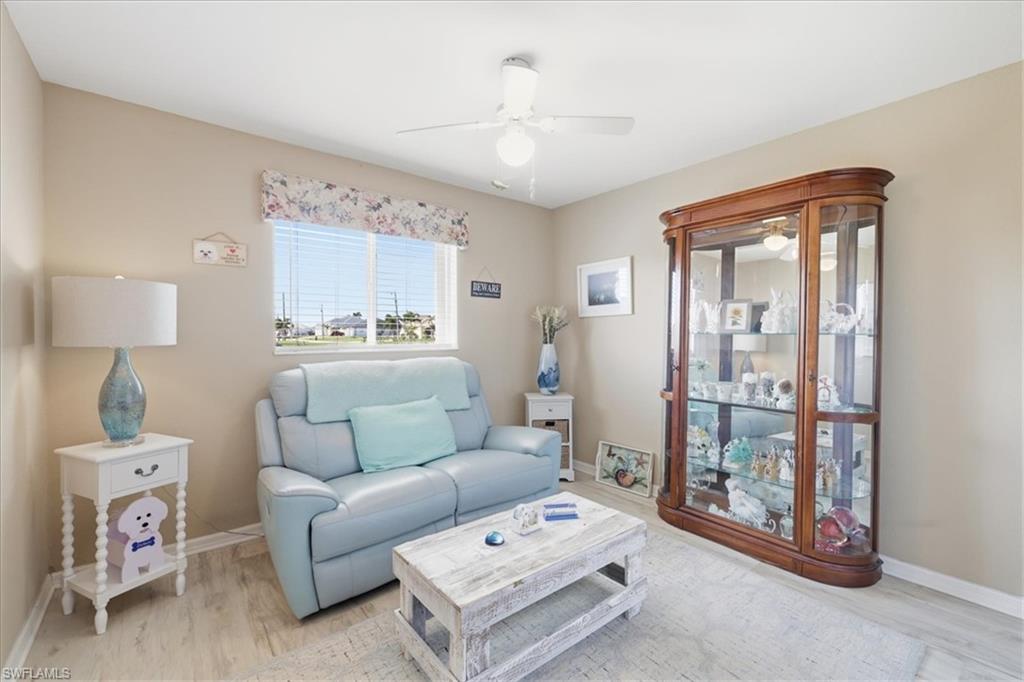 Living room with light wood-type flooring and a ceiling fan