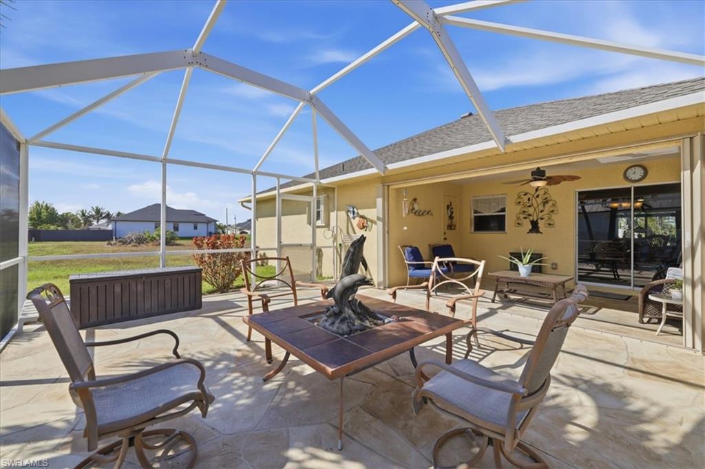 View of patio with glass enclosure, a sunroom, ceiling fan, and an outdoor living space