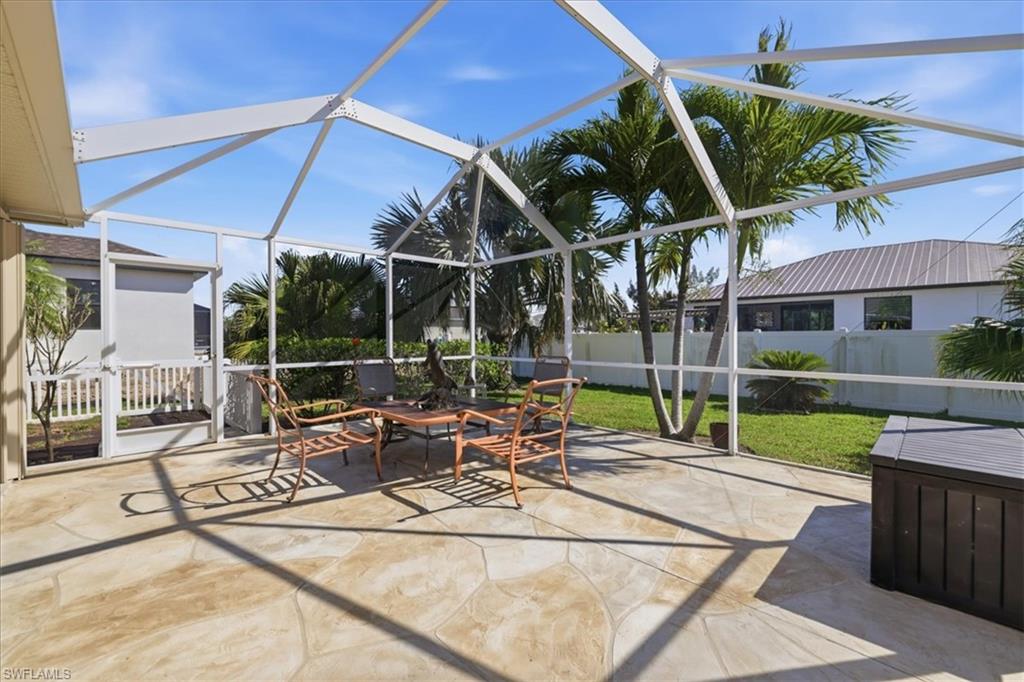 Fenced backyard with glass enclosure, a patio area, and a sunroom
