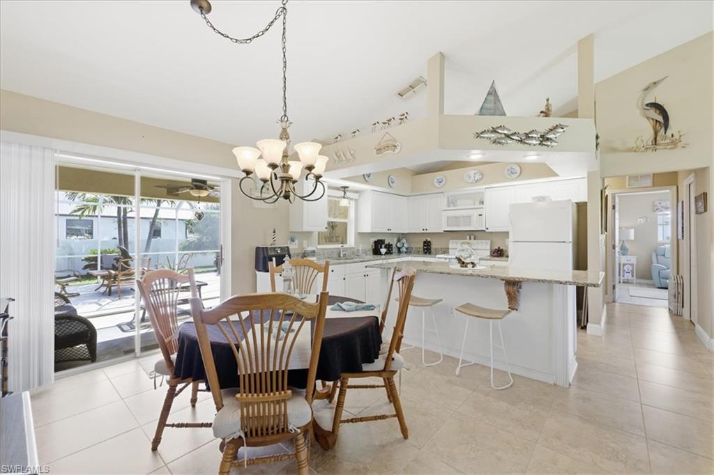Dining space featuring lofted ceiling, a chandelier, and light tile patterned floors