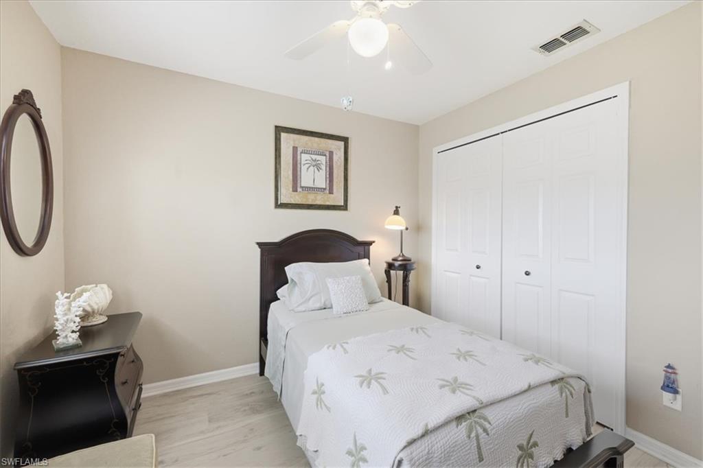Bedroom with light wood-style flooring, a ceiling fan, and a closet