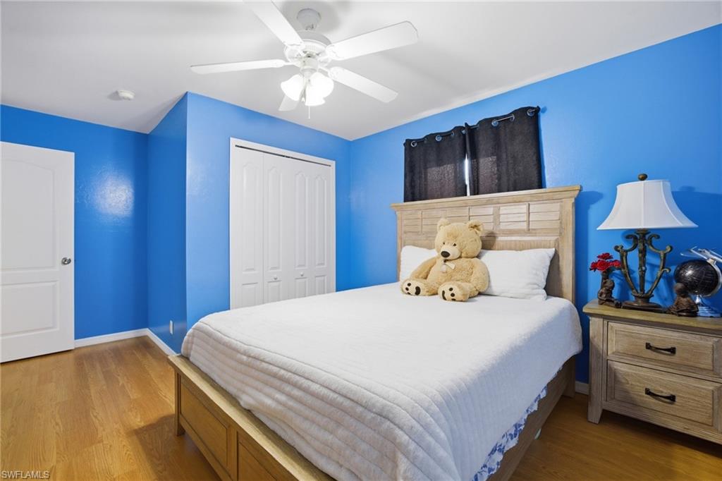 Bedroom featuring light wood-style flooring, ceiling fan, and a closet