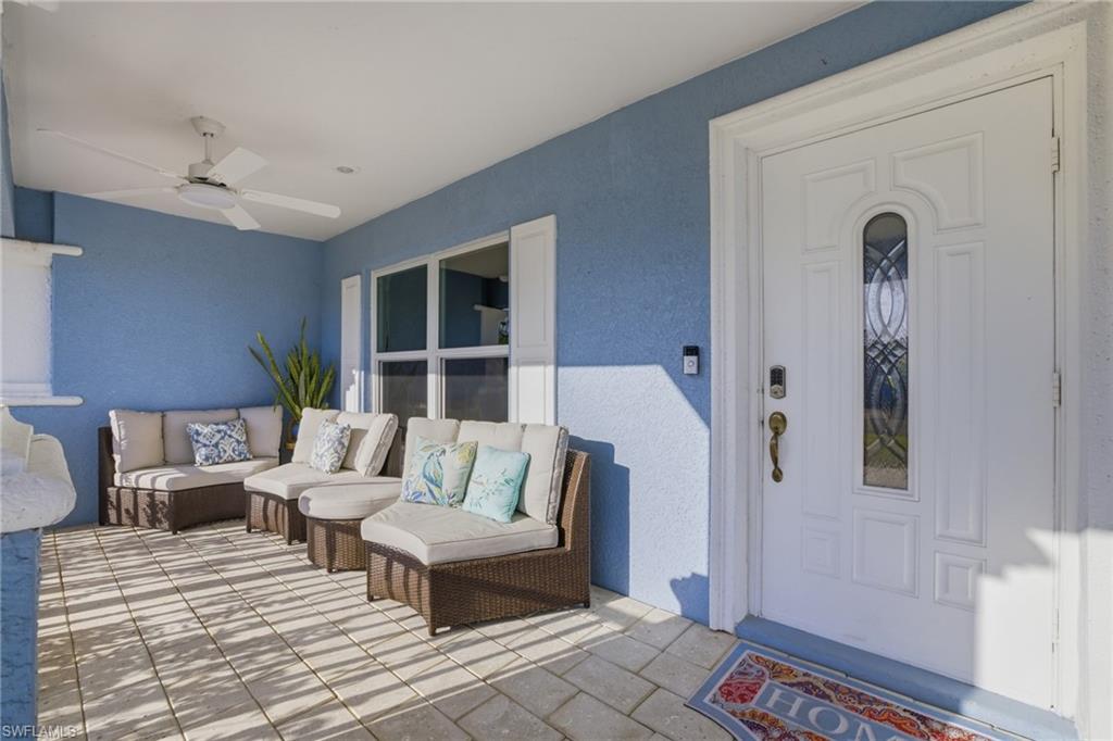 Property entrance featuring stucco siding, ceiling fan, and an outdoor lounge area
